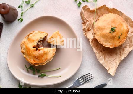 Piatto con gustose torte di carne su sfondo chiaro Foto Stock