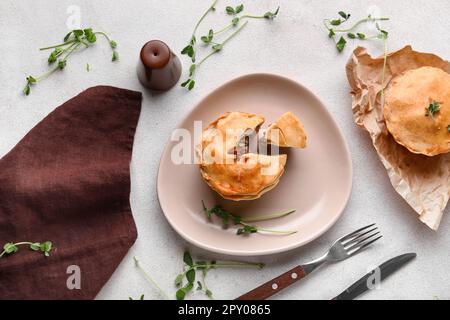 Piatto con gustose torte di carne su sfondo chiaro Foto Stock