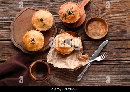 Tavole e piatto con gustose torte di carne su fondo di legno Foto Stock