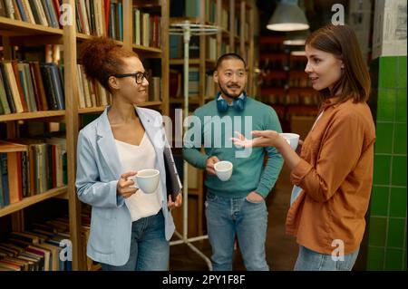 Diversi team di lavoro ridendo allegramente in ufficio coworking. Giovane businesspeople riuscito che prende la rottura corta durante il lavoro Foto Stock
