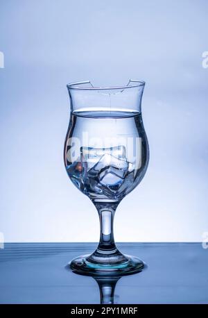 L'immagine di versare acqua potabile, in un vetro rotto, che fa sentire rinfrescato su sfondo bianco sfocato, spruzzi d'acqua, acqua frizzante, Foto Stock