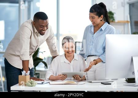 Dietro ogni grande commercio è una squadra che fa le cose grandi. un gruppo di uomini d'affari che utilizzano un tablet digitale insieme in un ufficio. Foto Stock