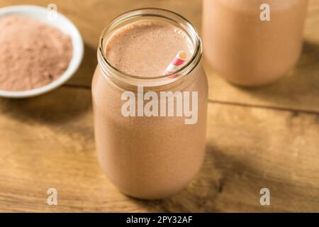 Proteina di siero di latte al cioccolato dolce congelato agitare con banana e latte Foto Stock