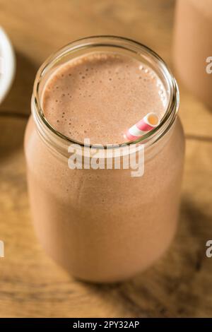 Proteina di siero di latte al cioccolato dolce congelato agitare con banana e latte Foto Stock