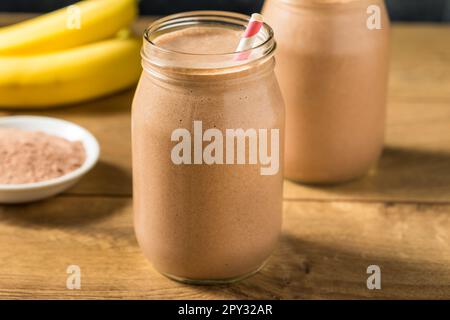 Proteina di siero di latte al cioccolato dolce congelato agitare con banana e latte Foto Stock