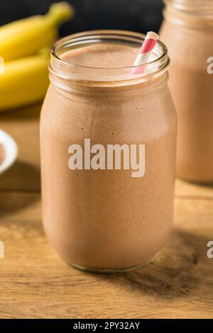 Proteina di siero di latte al cioccolato dolce congelato agitare con banana e latte Foto Stock