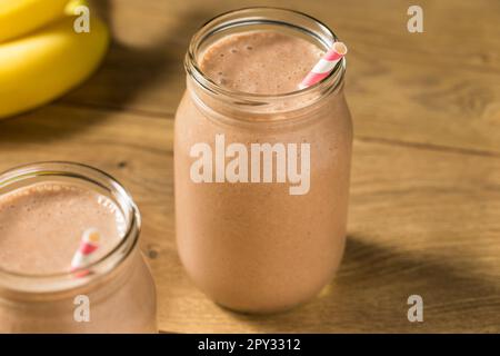 Proteina di siero di latte al cioccolato dolce congelato agitare con banana e latte Foto Stock