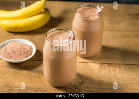 Proteina di siero di latte al cioccolato dolce congelato agitare con banana e latte Foto Stock