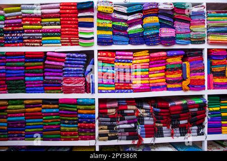 Varietà artistica tonalità colori Saree's impilati su scaffale del negozio in vendita Foto Stock