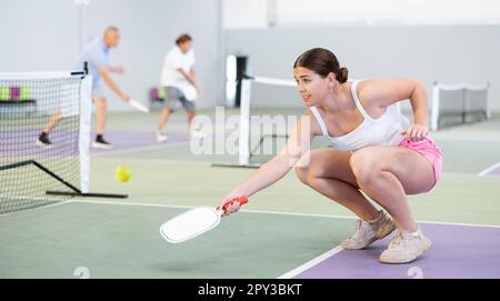 Giovane ragazza concentrata pickleball giocatore in attesa di ricevere servizio Foto Stock