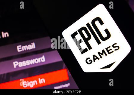 In questa immagine, il logo Epic Games viene visualizzato sullo schermo dello smartphone, accanto a una schermata di accesso, con e-mail, password e accesso. Foto Stock