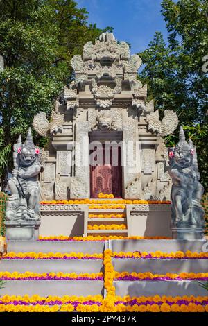 Tradizionale tempio balinese con spiriti di guardia. Decorato con fiori per le feste religiose. Foto Stock