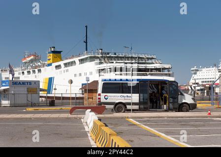 Candia, Creta, Grecia, UE. 2023. Un autobus cittadino di Heraklion in attesa di passeggeri nel porto con un backgrounf di traghetti. Foto Stock