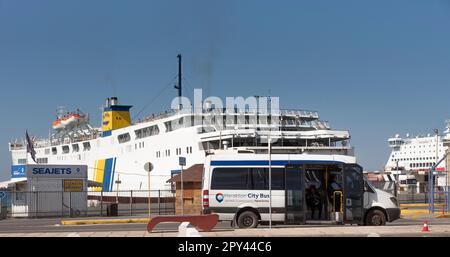 Candia, Creta, Grecia, UE. 2023. Un autobus cittadino di Heraklion in attesa di passeggeri nel porto con un backgrounf di traghetti. Foto Stock