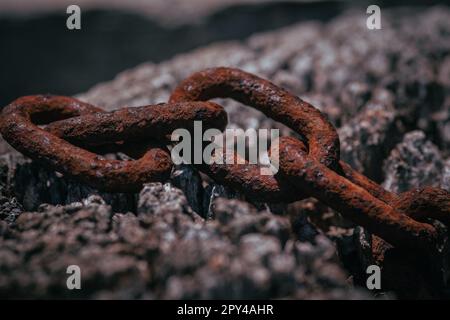 Catena arrugginita su un palo di legno Foto Stock