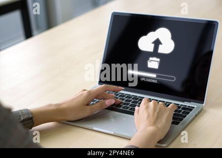 Vista posteriore di una donna che utilizza la tecnologia cloud drive carica i file salvati su Internet. Concetto di memorizzazione dati, networking e servizi Internet. Foto Stock