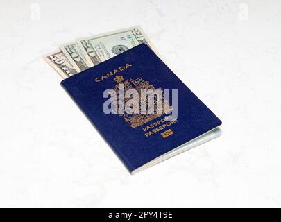 Canadian Passport e dollari americani su uno sfondo di marmo bianco Foto Stock