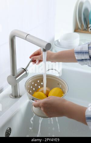 Acqua che scorre da toccare il montaggio su asparagi con scolapasta nel lavello  da cucina Foto stock - Alamy