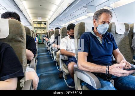 Passeggeri Vietnam Airlines che indossano mascherine sul volo da Bangkok al Vietnam Foto Stock