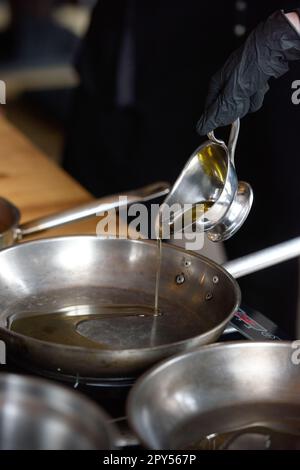 Versando olio vegetale in padella Foto Stock