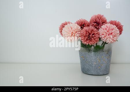 Bouquet di fiori artificiali di spugna rosa in vaso grigio argento su sfondo bianco. STILL Life, opzione di decorazione degli interni. Arredamento della camera. Spazio libero per il testo. Foto Stock