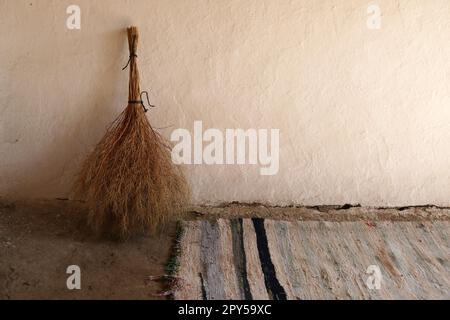 tappeto classico intrecciato a mano e scopa in erba fatta a mano, classici articoli per la casa del villaggio Foto Stock