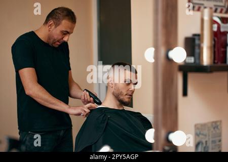 Barbiere uomo caucasico in barbiere Foto Stock