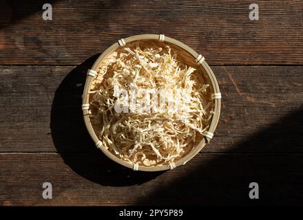 Kiriboshi-daikon (daikon essiccato) collocato su uno sfondo di alberi alla luce del sole. Foto Stock