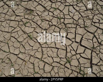 Profonde crepe nella terra come simbolo del clima caldo e della siccità. Deserto e terreno incrinato. Terreno irregolare, gonfio. Vuoto e morte. Tema ecologico e naturale. Foto Stock