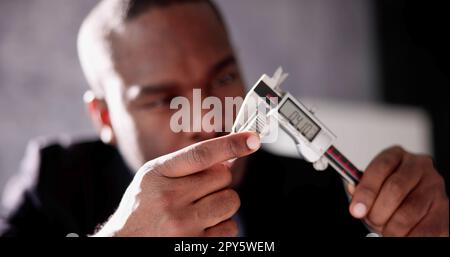Misurazione del calibro digitale per mano dell'uomo africano Foto Stock
