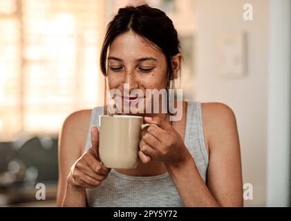 MMM...puzza di buon mattino. una giovane donna che si gode una tazza di caffè a casa. Foto Stock