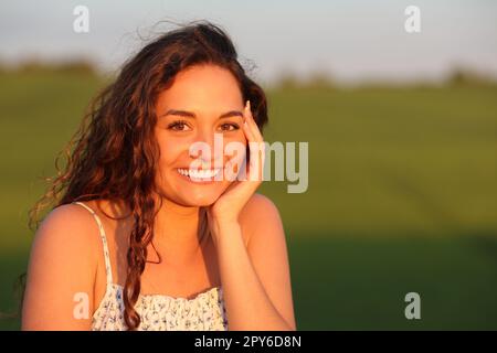 Bella donna felice che posa in un campo Foto Stock