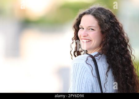 Donna felice che posa e sorride per strada Foto Stock