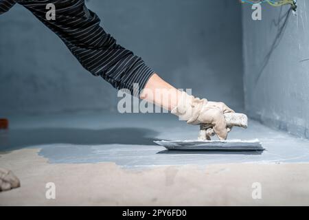 lavoro manuale con impermeabilizzazione bagno con cazzuola Foto Stock