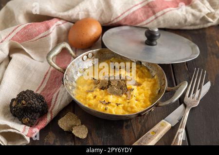 Uova strapazzate con tartufi neri freschi italiani serviti in padella, colazione da buongustai Foto Stock