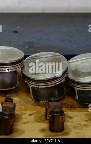 parti di ricambio come pistoni, valvole e altri componenti di motori a benzina in fase di revisione e riparazione Foto Stock