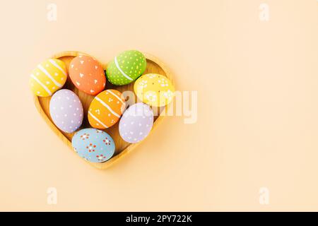 Overhead uova di pasqua in forma di cuore isolato su sfondo pastello Foto Stock