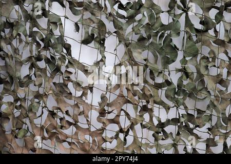 Primo piano di una rete mimetica per uso militare - texture di sfondo. Foto Stock