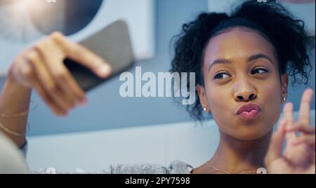 Goodnight World. una giovane donna attraente che prende selfie con il suo cellulare mentre si rilassa sul suo letto di notte. Foto Stock