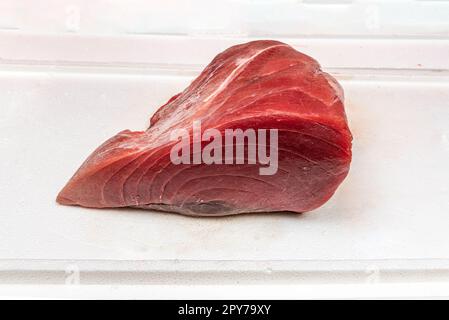 Un taco di tonno rosso su una superficie di poliuretano bianco Foto Stock