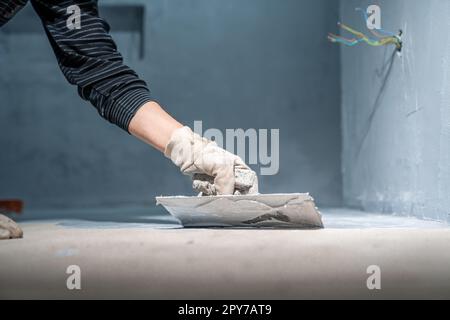 lavoro manuale con impermeabilizzazione bagno con cazzuola Foto Stock