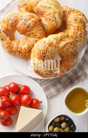 ACMA Turco in stile Soft Bagels servito con pomodoro, formaggio, olio d'oliva e olio di oliva closeup sul piatto sul tavolo. Vista verticale dall'alto Foto Stock