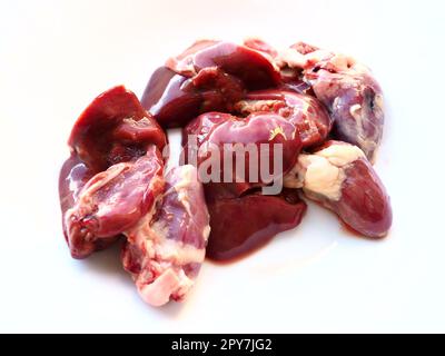 fegato di pollo crudo, reni e cuore. Entrini e frattaglie di pollame, preparati per la cottura. Una dieta ricca di ferro eme contro l'anemia. Carne su sfondo bianco Foto Stock