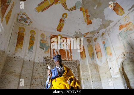 Megab, Etiopia - 9 gennaio 2018: Un sacerdote all'interno della Chiesa di Daniel Korkor nei monti Gheralta, Tigray, Etiopia. Foto Stock