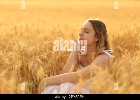 Donna che si rilassa da sola in un campo Foto Stock