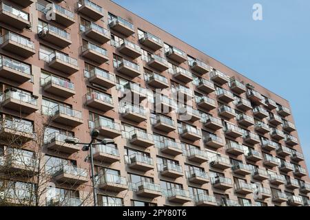 Facciata di un grande blocco di appartamenti con architettura semplice e regolare a Bucarest. Motivi ripetitivi di finestre e balconi. Foto Stock