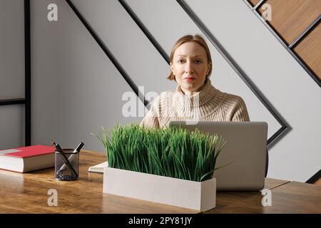 Una donna sicura di sé lavora in ufficio Foto Stock