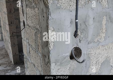 Cablaggio elettrico per il montaggio di un interruttore durante la costruzione di un edificio residenziale privato Foto Stock