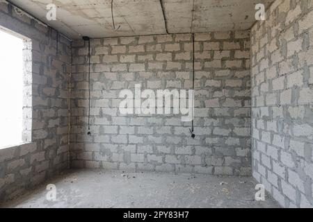 Costruzione di un singolo edificio residenziale, una vista della parete di cemento argilloso espanso senza finitura, fili elettrici sono posati Foto Stock