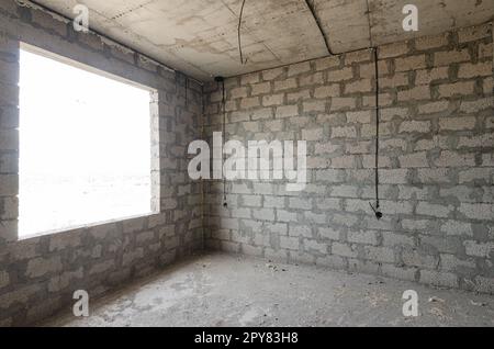 La costruzione di un edificio residenziale individuale, una vista della parete di cemento argilloso espanso senza finiture e una grande finestra spaziosa Foto Stock